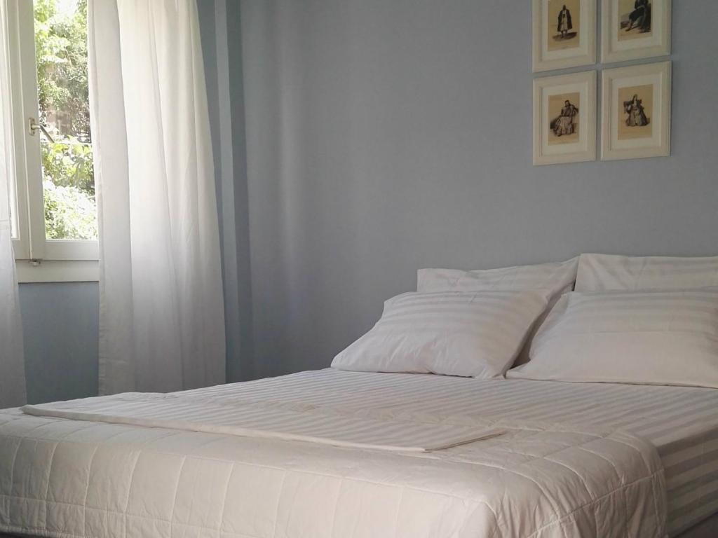 ルートラキにあるParis Spacious Beach Apartmentの窓付きのベッドルームの白いベッド1台