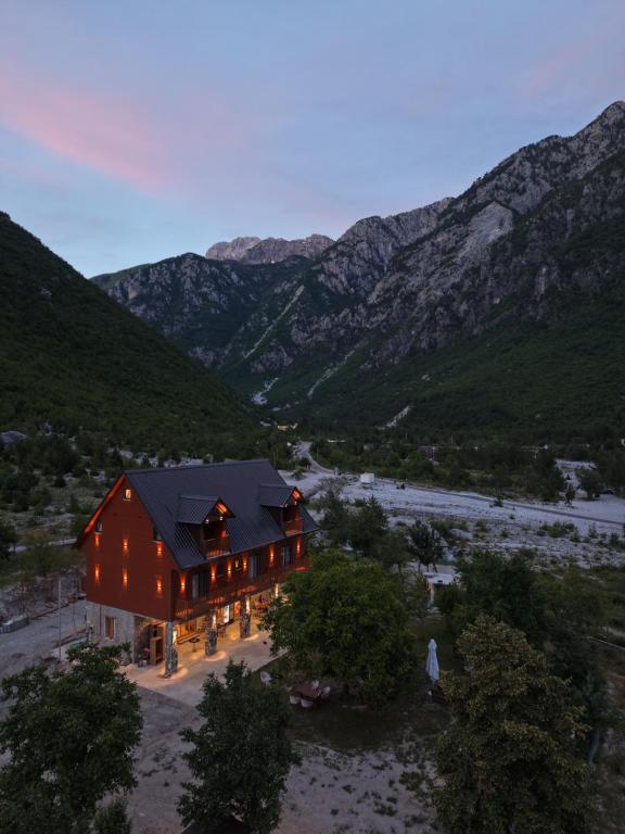 an aerial view of a barn with mountains in the background at Old Mill Heritage Hotel in Ndërlysaj