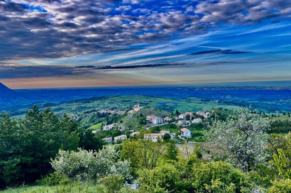 a town on a hill with trees and the ocean at Casa vacanze nel Parco della Majella in Montenerodomo