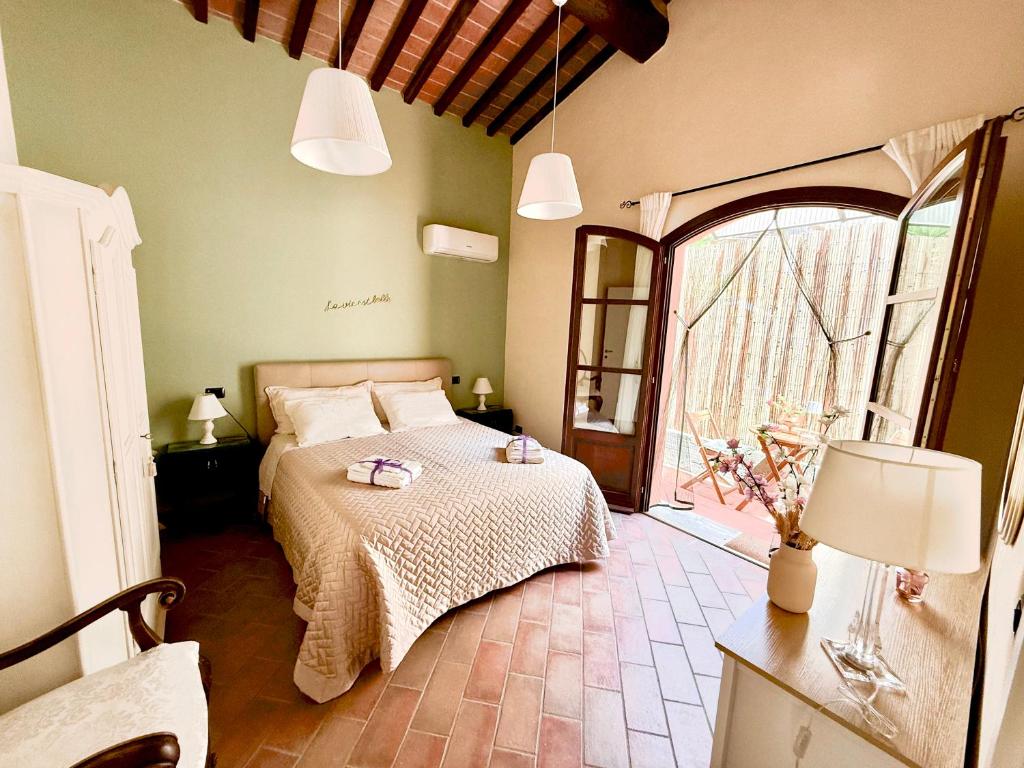 a bedroom with a bed and a large window at Cottage La Fornace in Vicopisano