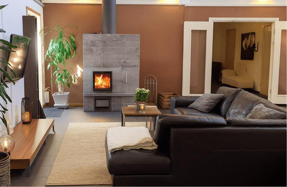 a living room with a couch and a fireplace at Rum För Resande in Skellefteå