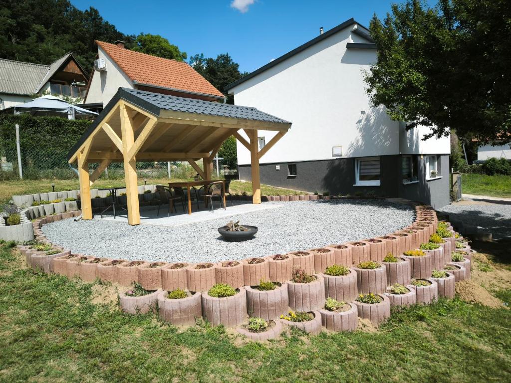 a circular garden with a pavilion and a picnic table at Döbrönte MagLak in Döbrönte