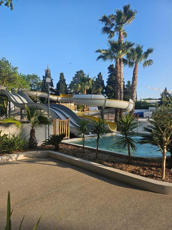 a water park with a water slide and palm trees at camping des 7 fonts in Agde