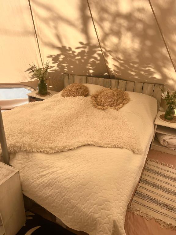 a bed in a tent with two pillows on it at Muhu Leeni Glamping in Kuivastu