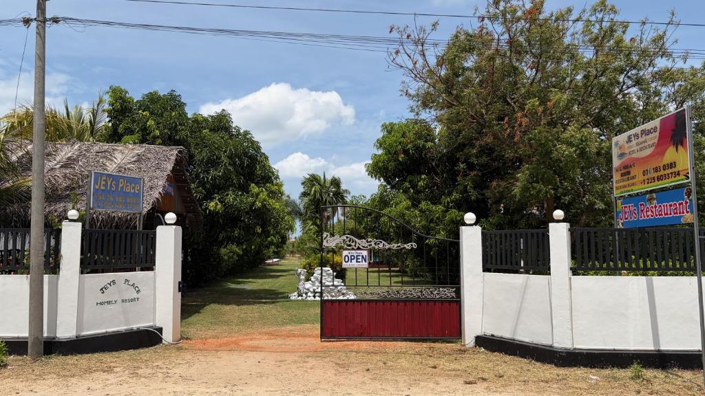 a gate with a red and white fence at JEYs Place in Nilaveli