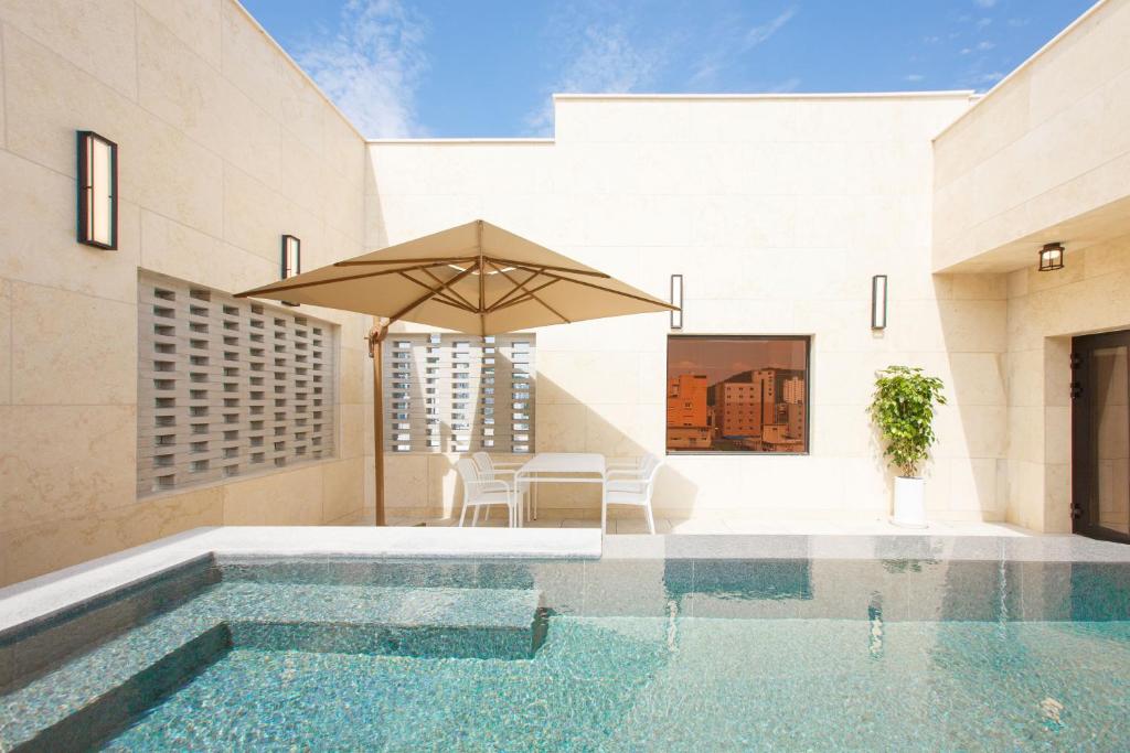 a house with a swimming pool and an umbrella at Hotel Ieum Mokpo peace square branch in Mokpo