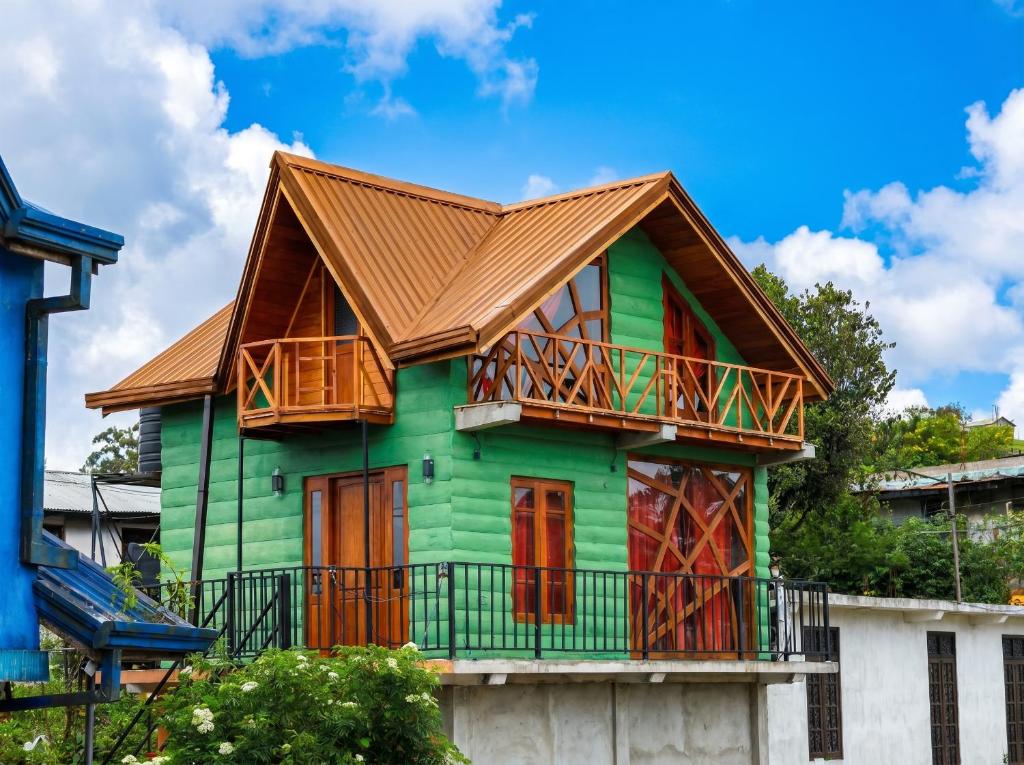 a green house with a brown roof at The Cloud-Line Cabana in Nuwara Eliya