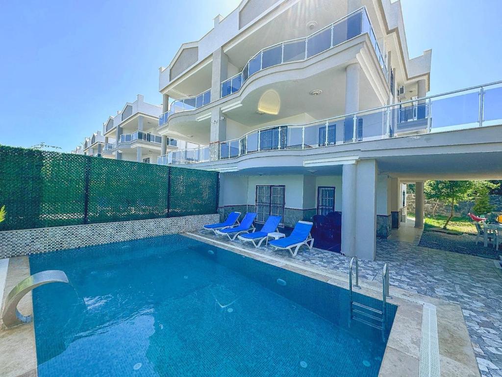 a house with a swimming pool in front of a building at Villa Incir in Kuşadası