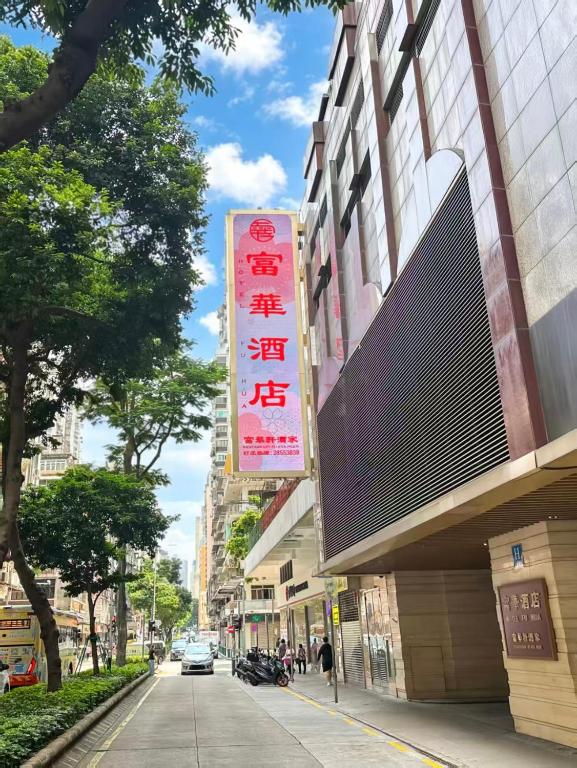 a building with a sign on the side of a street at Fu Hua Hotel in Macau