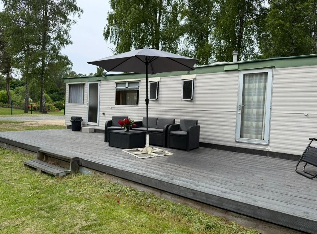 a deck with an umbrella and a couch and chairs at The Sea Spot in Zvejniekciems