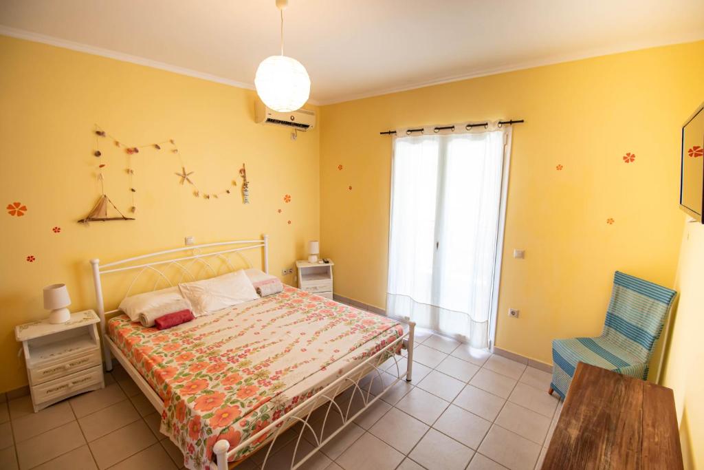 a bedroom with a bed and a chair and a window at Villa Ladina in Lygia