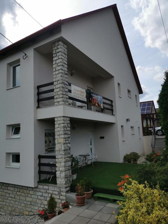 a large white building with a brick chimney at Napolá apartman in Balatonalmádi