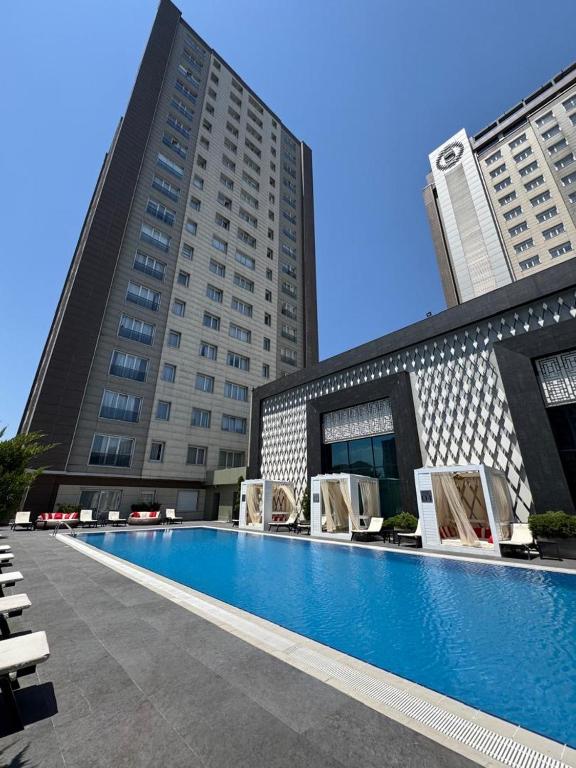 a swimming pool in front of two tall buildings at Bishkek Park Apartments in Bishkek