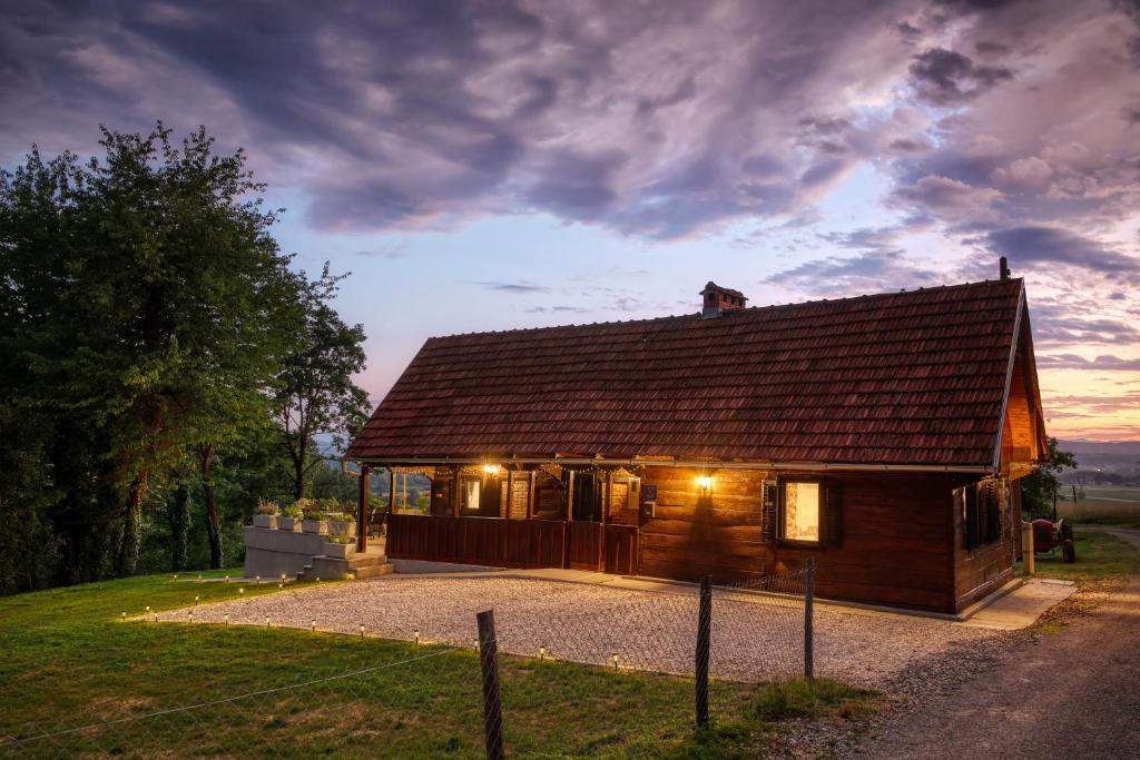 ein kleines Holzhaus mit eingeschaltetem Licht in der Unterkunft Aurora Silvae in Ozalj