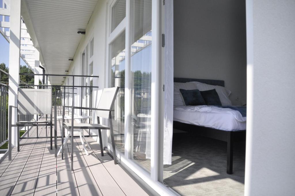 a room with a bed on a balcony at Victoria Ustka Pokoje i Apartamenty Blisko Plaży in Ustka