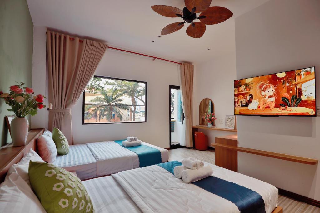 a hotel room with two beds and a flat screen tv at Emlyhome Hanriver in Danang
