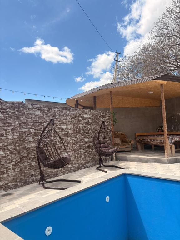 two chairs sitting on a patio next to a swimming pool at fam rest in Garni