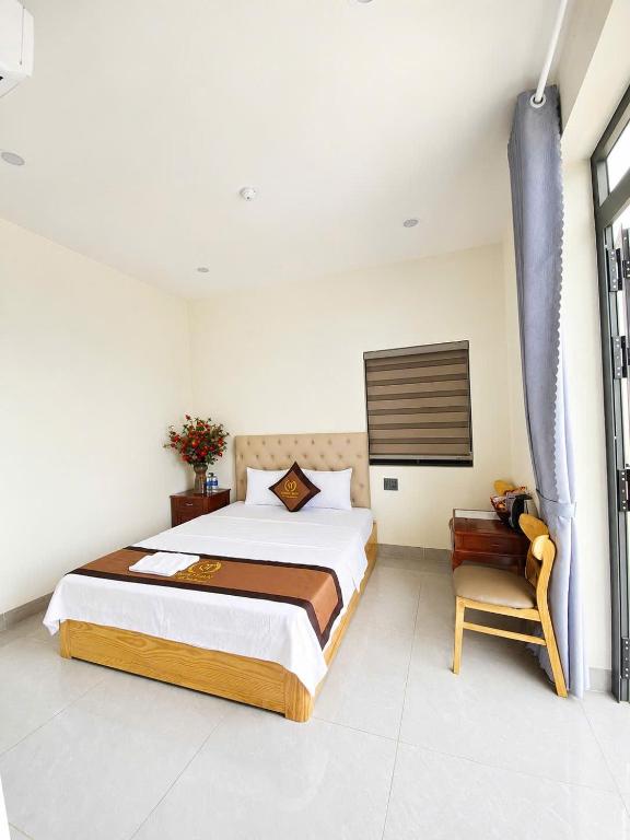 a bedroom with a large bed and a chair at Hotel QUỐC TUẤN in Ban Ay Dlă (2)