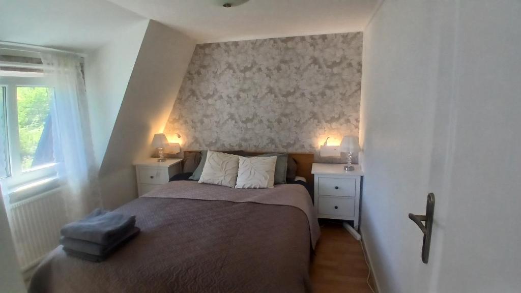 a small bedroom with a bed and two night stands at Berghaga in Köping