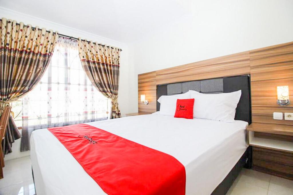 a bedroom with a large bed with a red blanket at RedDoorz near UGM 3 in Yogyakarta
