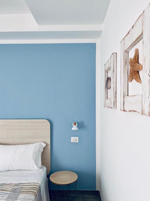 a bedroom with a blue wall with a bed and a table at Dimora del Corso - Rooms in Mattinata