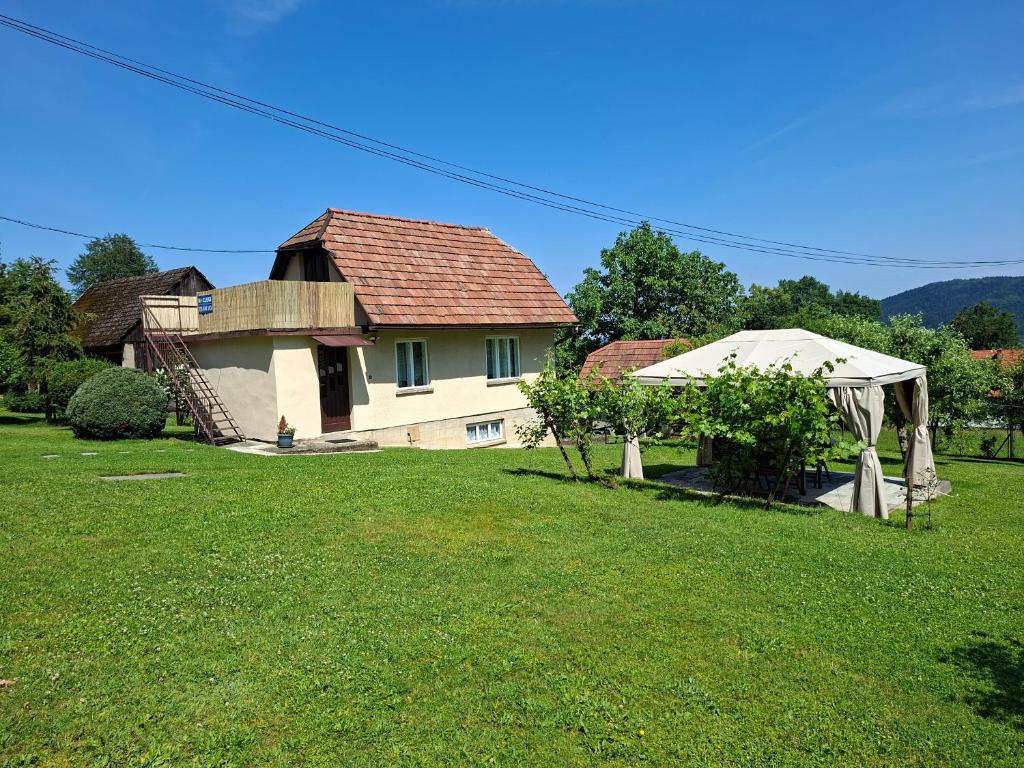 a house with a gazebo in a yard at Chatka przy kapliczce in Bugaj
