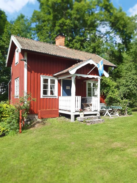 a red house with a picnic table in front of it at RÖDA STUGAN PÅ SLINKEN in Sala