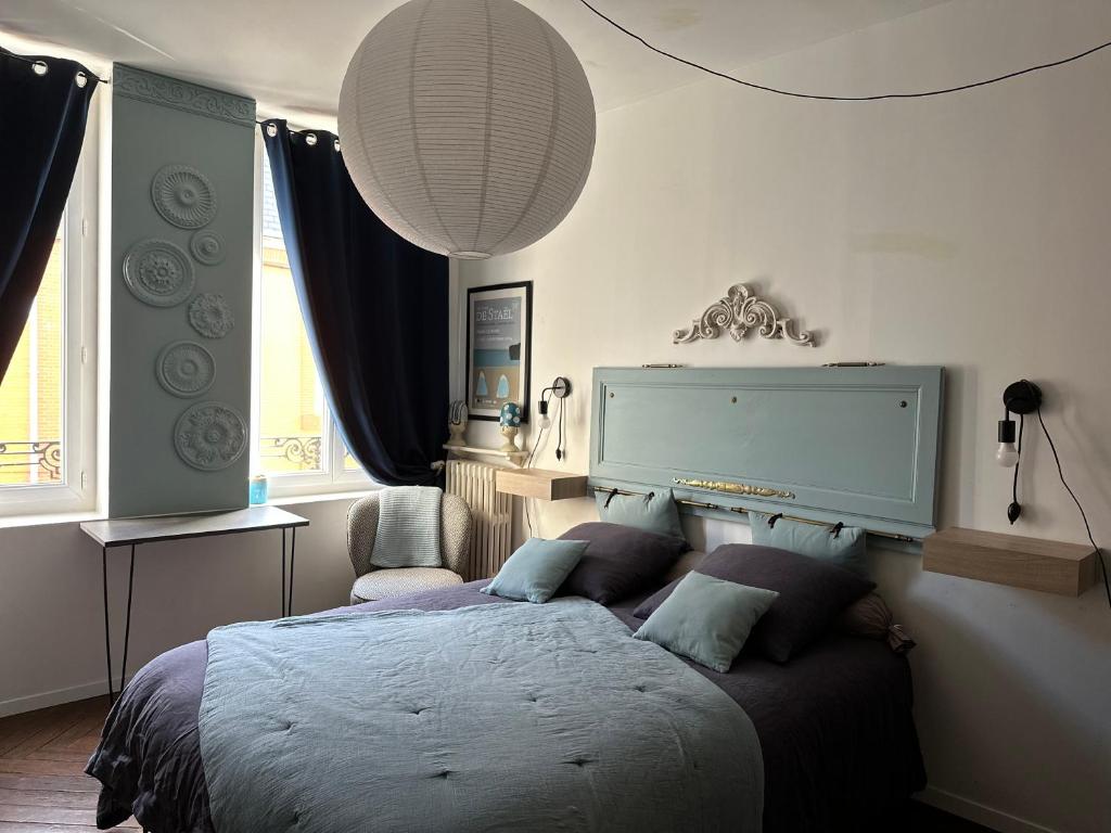 a bedroom with a bed and a large window at Chez Anne in Fécamp