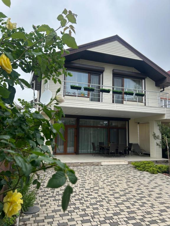 a large white house with a brick patio at Villa Life Family Sea House in Zatoka