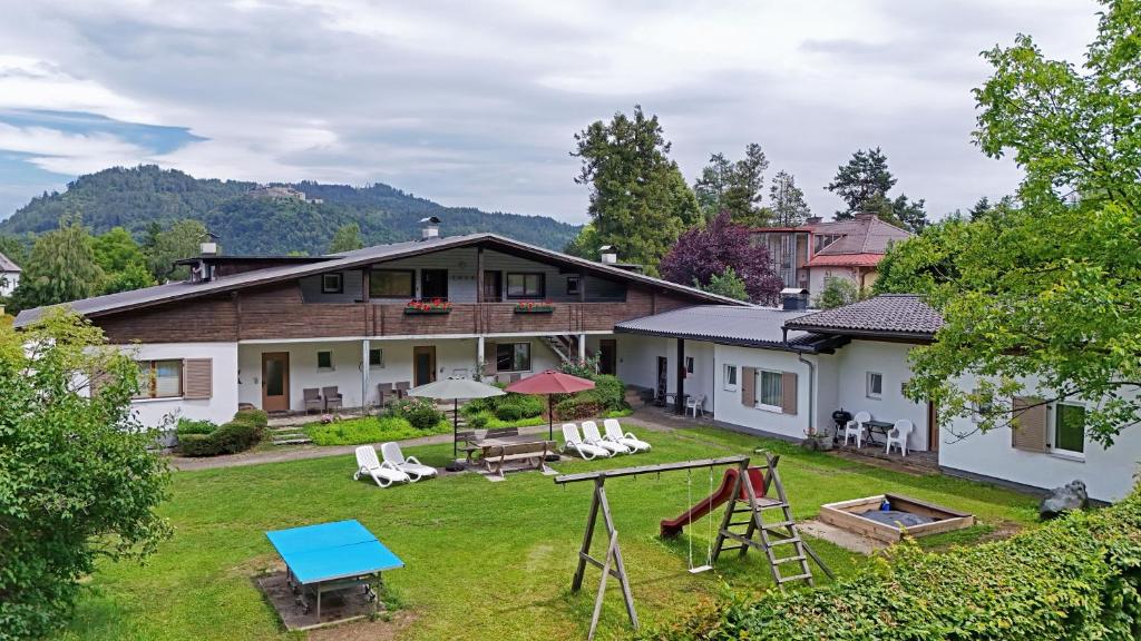a house with a yard with a playground at Ferienwohnungen Benedikt in Villach