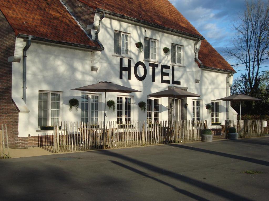 un hotel con sombrillas frente a un edificio en Hotel Amaryllis en Maldegem