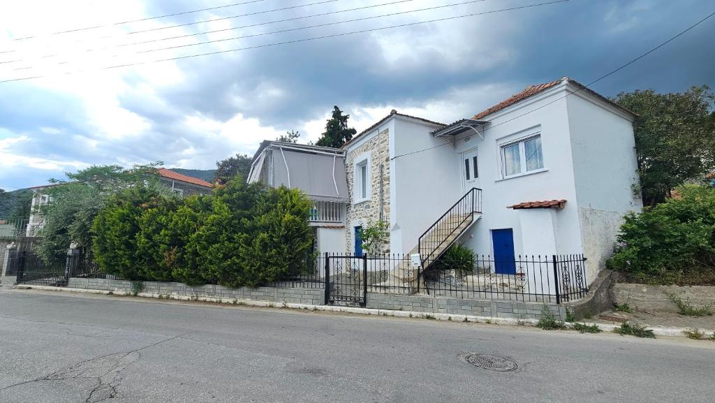 a white house on the side of a street at Olive Garden Estate in Elevtheraí