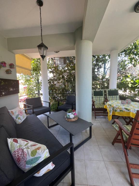 a living room with a couch and a table at Villa VG- Calm and relax in Nea Vrasna
