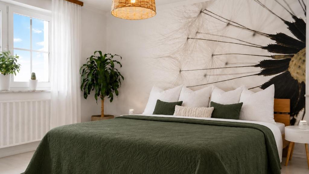 a bedroom with a large bed with a green blanket at Wintergarten Wohnung mit Feldblick nahe Legoland in Jettingen-Scheppach