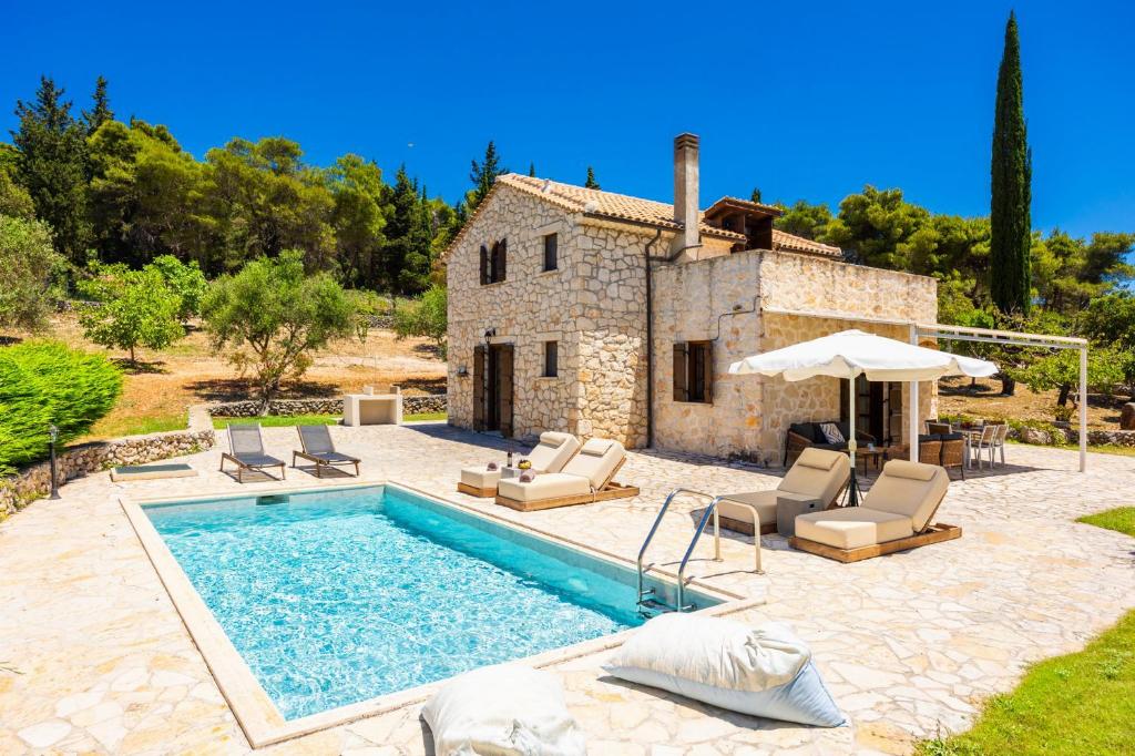 a villa with a swimming pool in front of a house at Villa Boscheto Pente in Agios Leon
