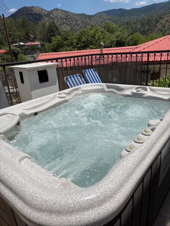 a jacuzzi tub on a patio with two chairs at Love Holiday Suite 1 in Tris Elies