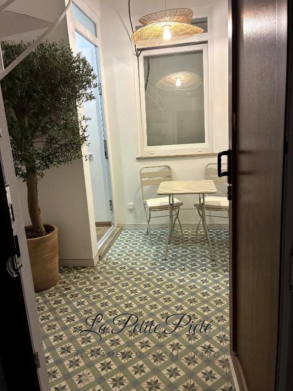 a room with a table and a table and a chair at La Petite Piété in Faro