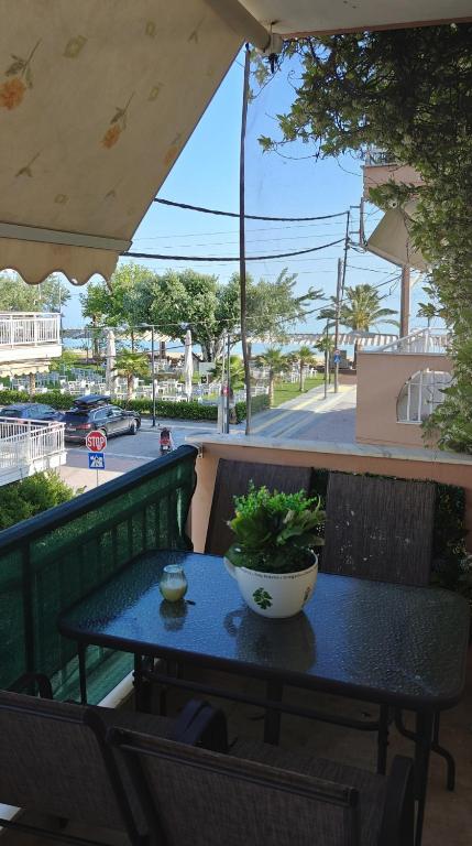 a table with a potted plant sitting on a balcony at NiK Seaview Suite Balcony Steps from Beach in Flogita