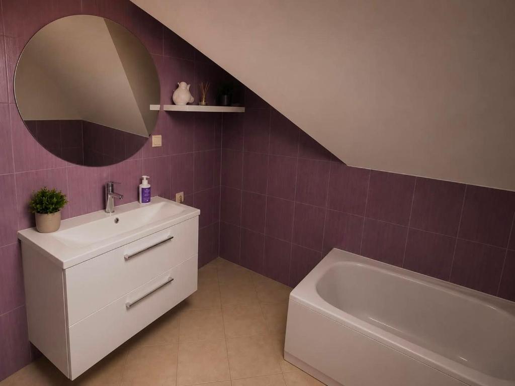 a bathroom with a sink and a tub and a mirror at Wynajem pokój kinga Kujawska in Sztutowo