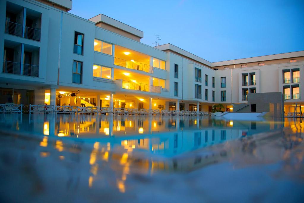 - un bâtiment avec une piscine en face dans l'établissement Hotel Terme Marine Leopoldo II TERME & SPA, à Marina di Grosseto
