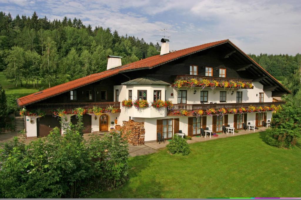 Una casa grande con flores al costado. en Pension Sonnleit´n - Urlaub mit Hund, en Zwiesel