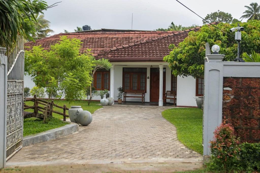 a house with a brick walkway leading to the front door at Lullaby Marine Villa in Wadduwa