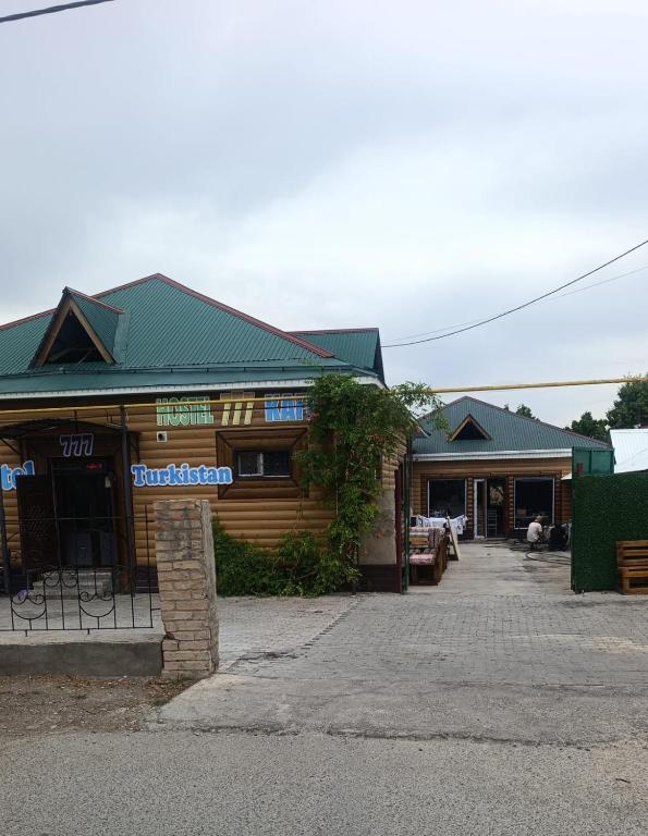a building with a sign on the front of it at Guest House 777 in Türkistan