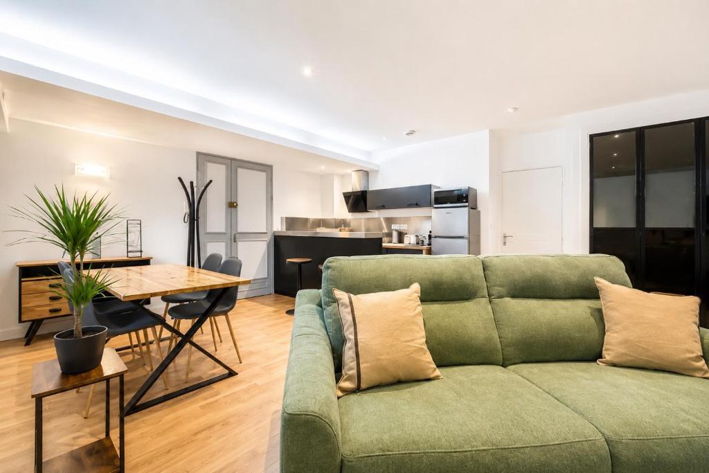a living room with a green couch and a table at T2 Spacieux & Lumineux Hyper Centre in Angers