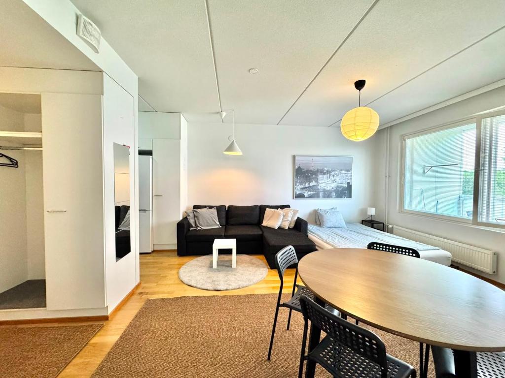 a living room with a couch and a table at Warm and cozy one-bedroom & Sauna in Vantaa