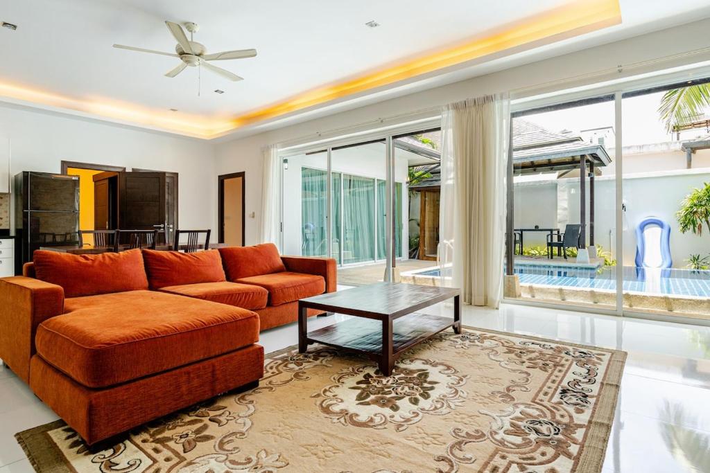 a living room with a couch and a table at Private pool villa in Kamala Beach