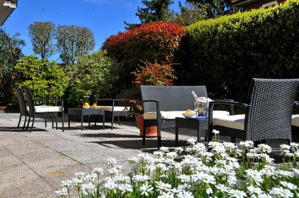 un gruppo di sedie e tavoli in giardino di Hotel Astoria a Desenzano del Garda