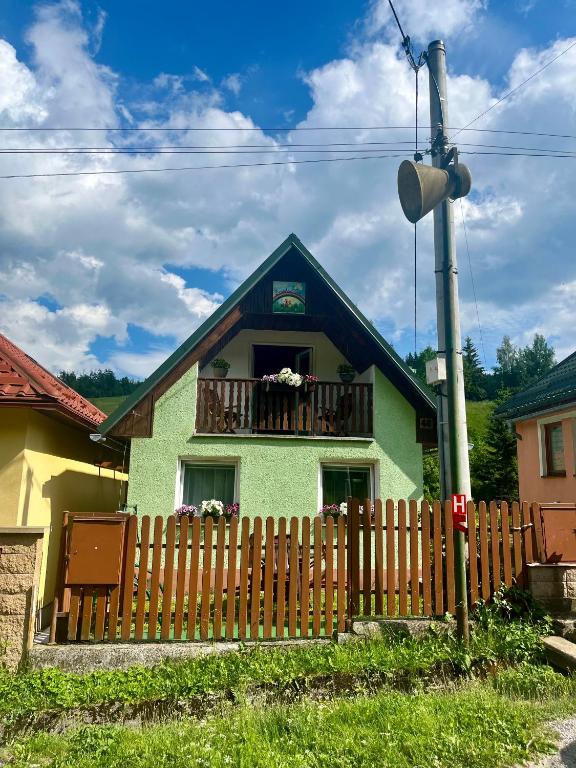 a green house with a fence in front of it at Domček u Ferka in Dedinky