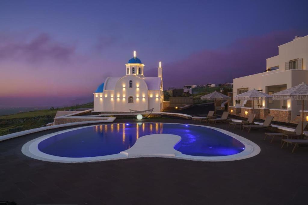 a swimming pool in front of a building at night at Marvel Suite in Imerovigli