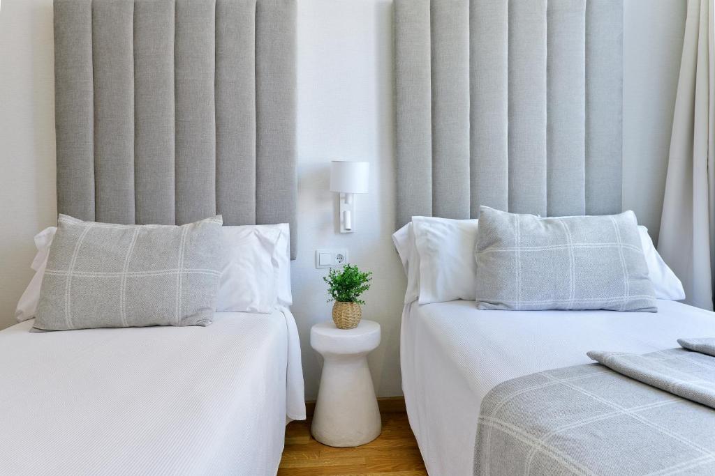a bedroom with two beds with white pillows at Hostal Zahara in Ferrol